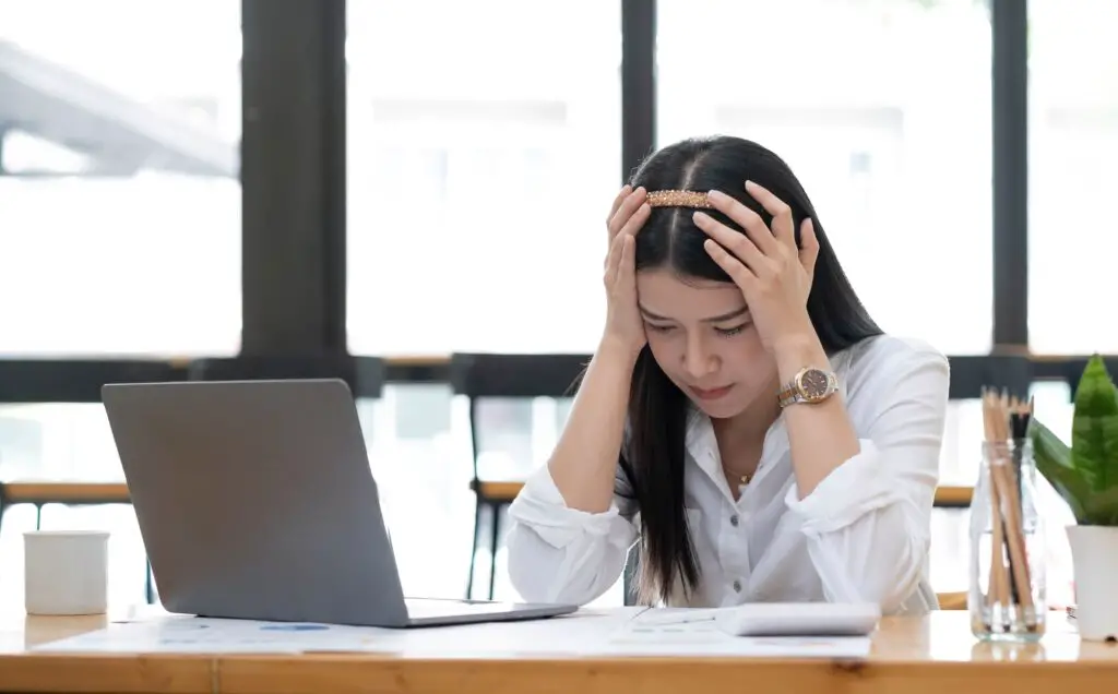 Image of an Asian business woman is stressed, bored, and overthinking from working on a tablet at