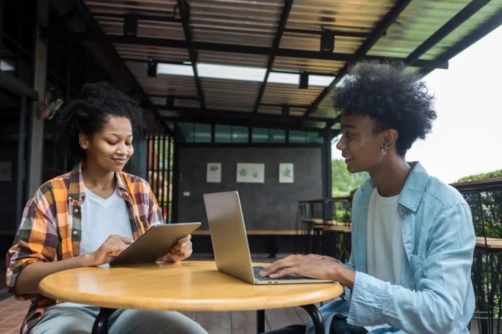 Student Life. Two students in school and working on laptop, checking social media