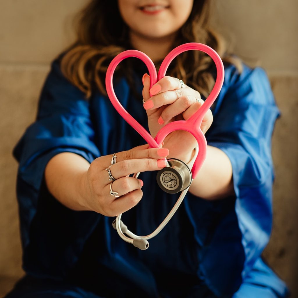 girl in blue jacket holding red and silver ring