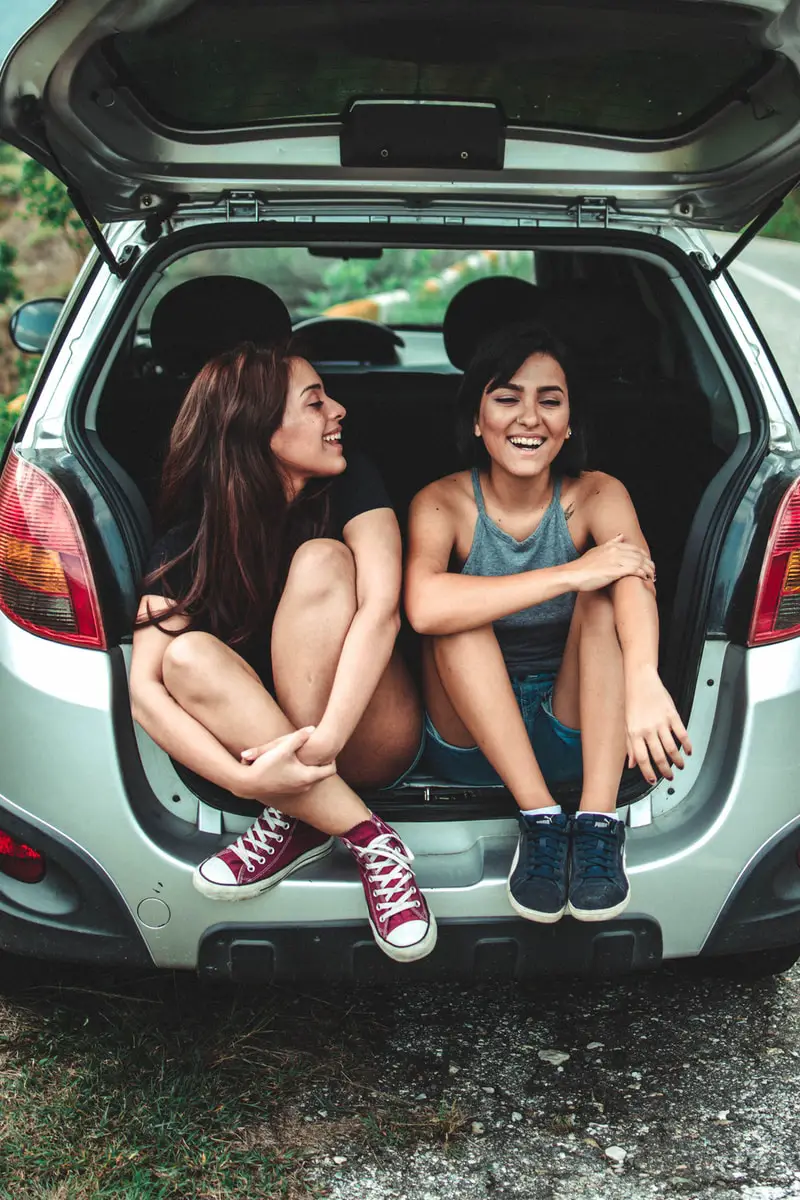 two students sitting at the back of the car