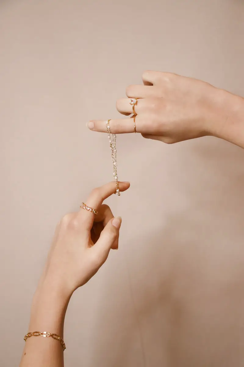 student holding silver chain necklace