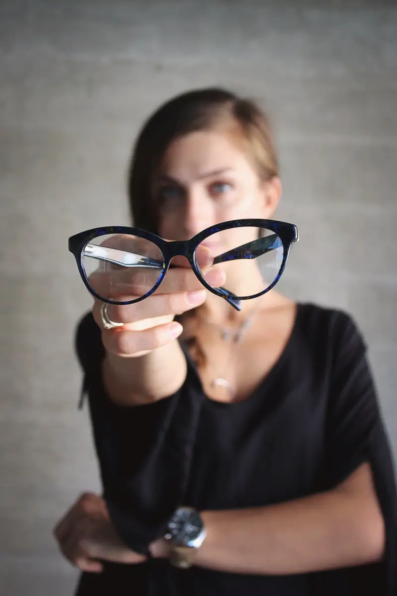 selective focus photo of eyeglasses held by student