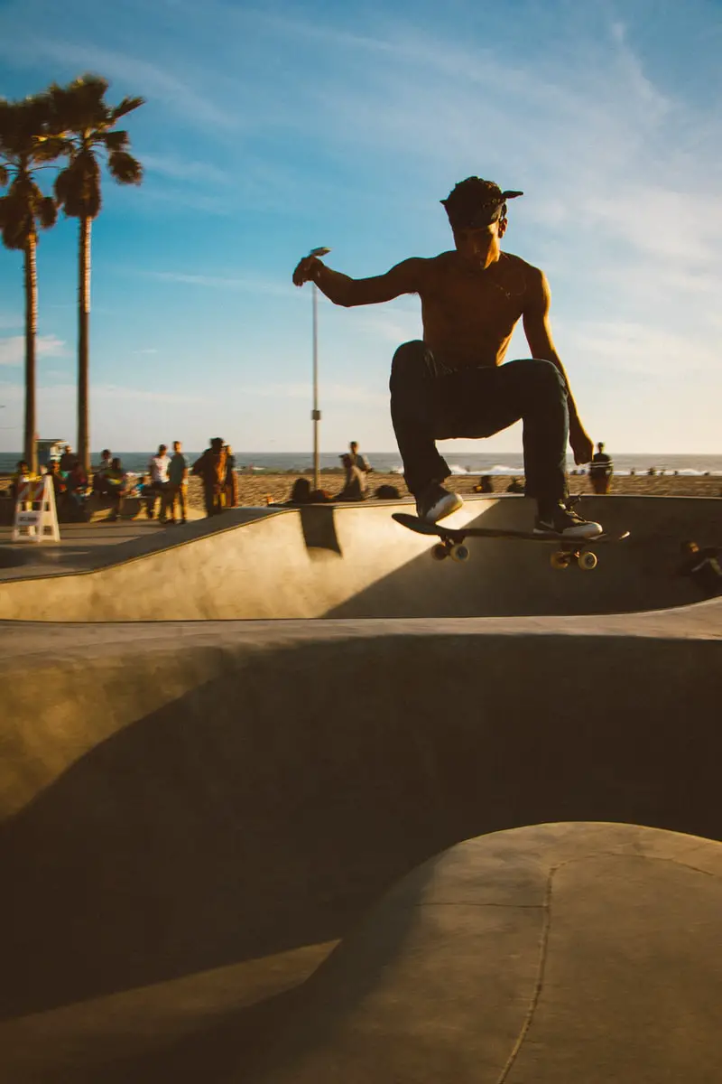 student doing tricks on skateboard on skateboard rail