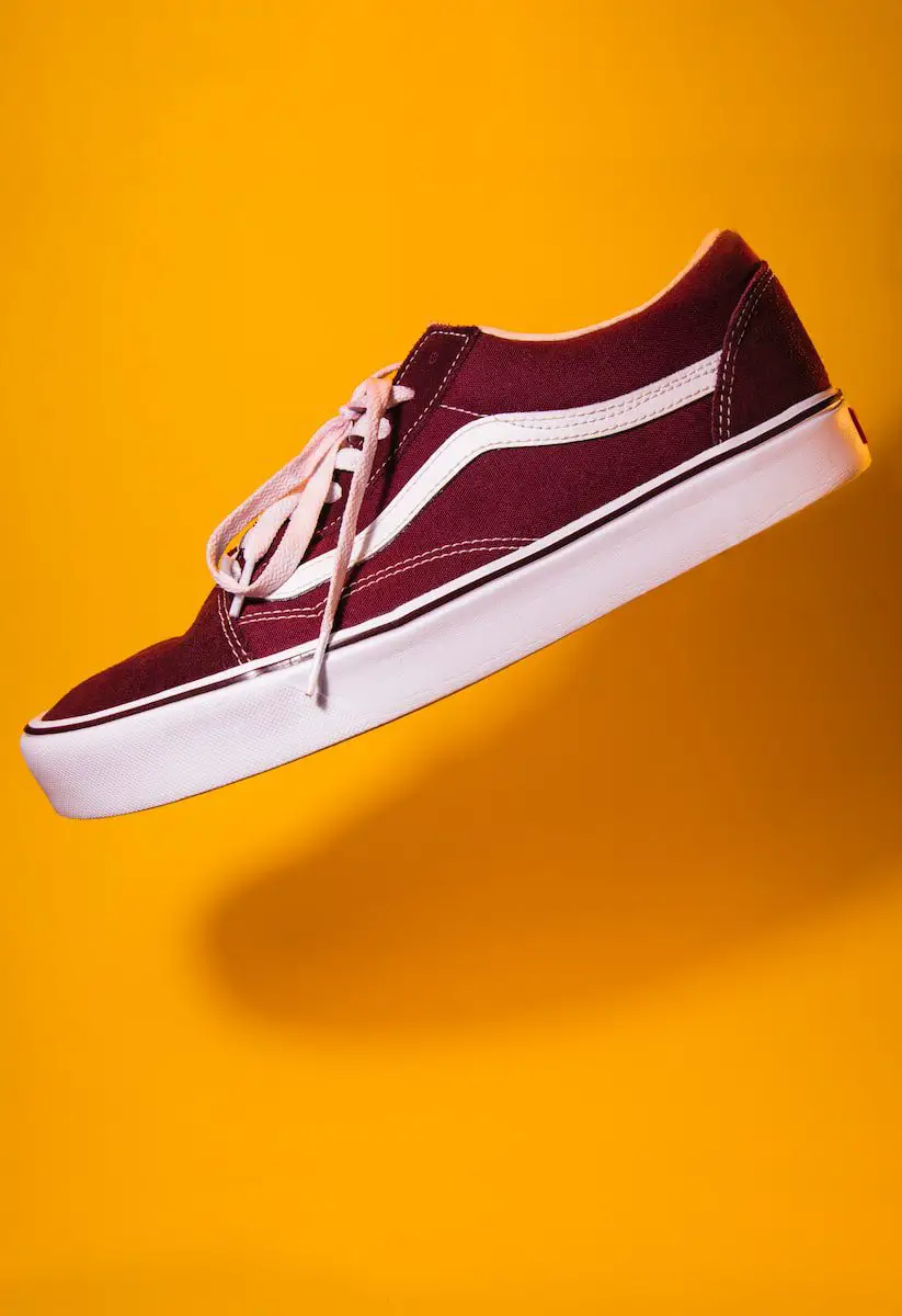 student maroon plimsoll on top of yellow textile