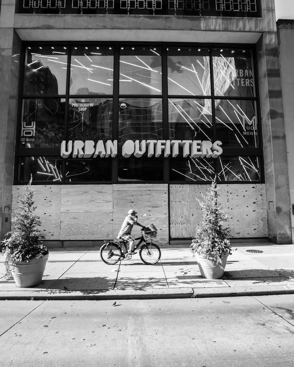 grayscale photo of student riding bicycle in front of the UNKs coffee shop