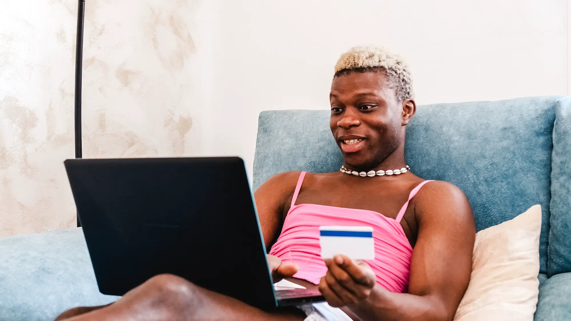 Black transsexual person making online purchases with credit card at home